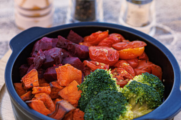 A round black bowl filled with an assortment of roasted vegetables