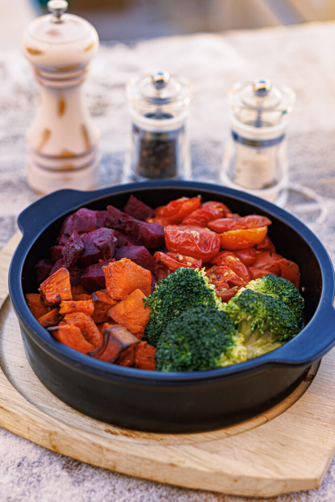 A round black bowl filled with an assortment of roasted vegetables